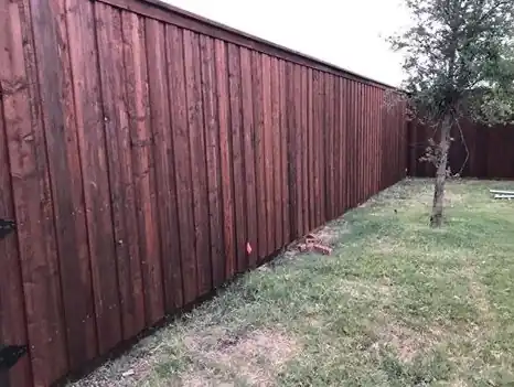 Long stained board-on-board cedar fence running along the yard