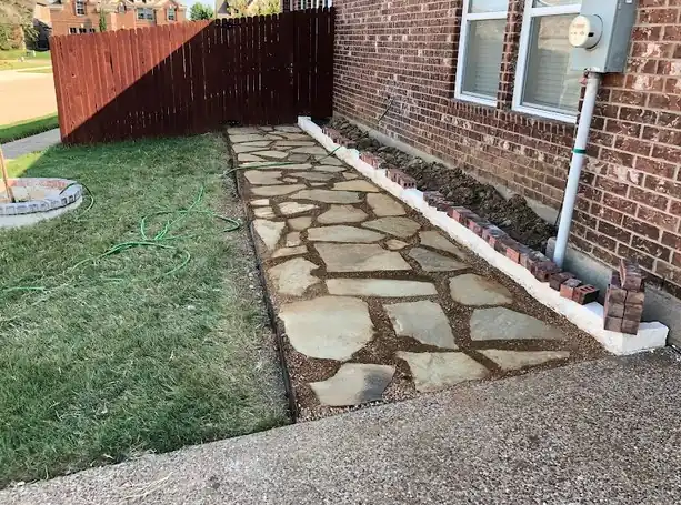 Flagstone path laid along a brick wall and fence